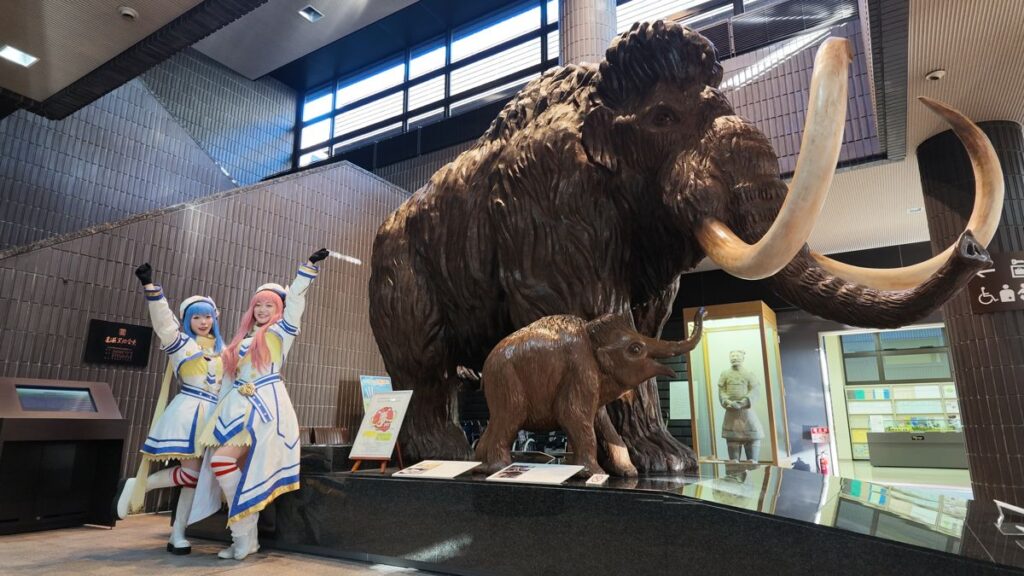 マンモス像の前のコスプレイヤー2人